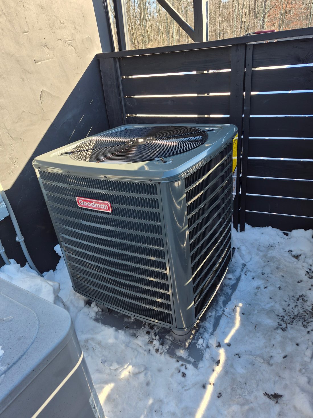 Goodman condenser running through a Pennsylvania winter, snow cleared around the pad